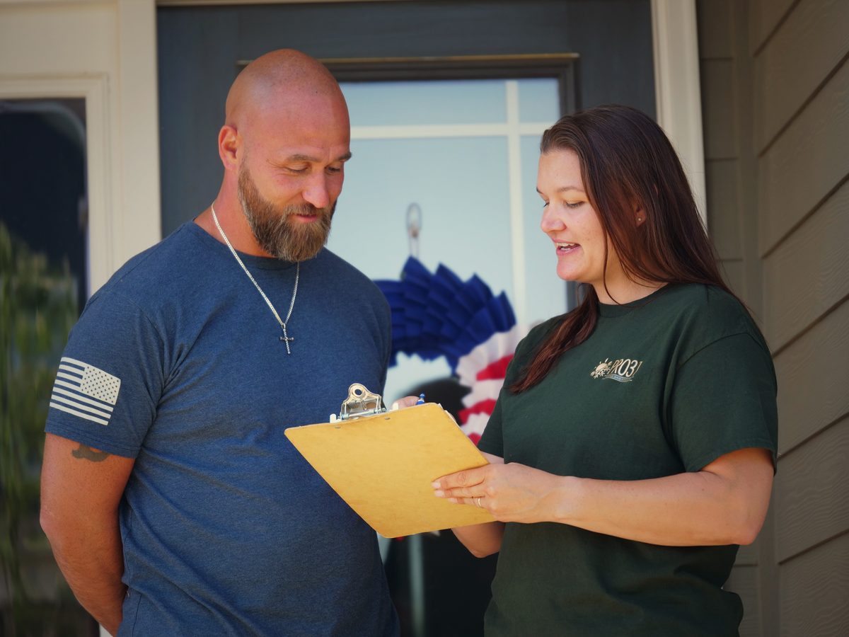 Rachelle on a customer's doorstep with a clipboard, ready to start a service call